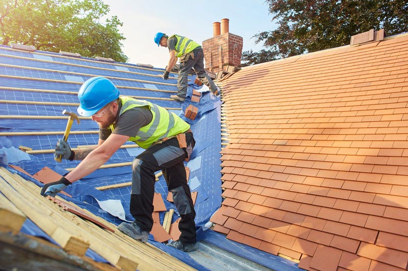 Roofer working at sunset